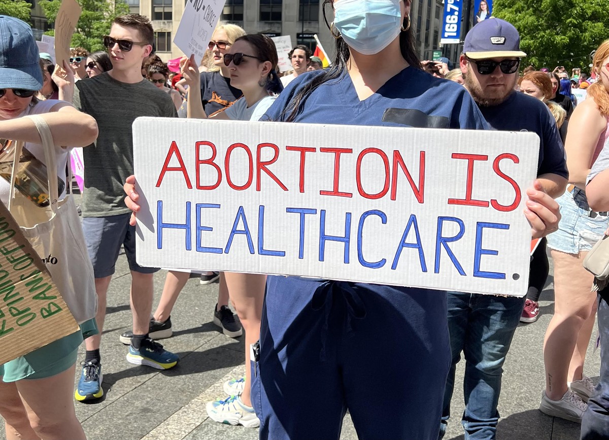 A nurse holds a sign in support of abortion access at a Planned Parenthood rally in Downtown Cincinnati on May 15, 2022.