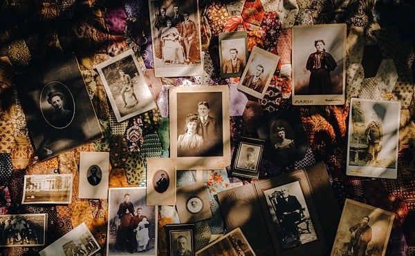 Photos and tintypes of people possibly buried in West Price Hill's Potter's Field lay scattered across a quilt on the cemetery's historic carriage path. Trees and Honeysuckle overgrowth, some containing the organic matter of those buried below, shade the mysterious faces not yet identified by Potter's advocate, Sandy Rice.