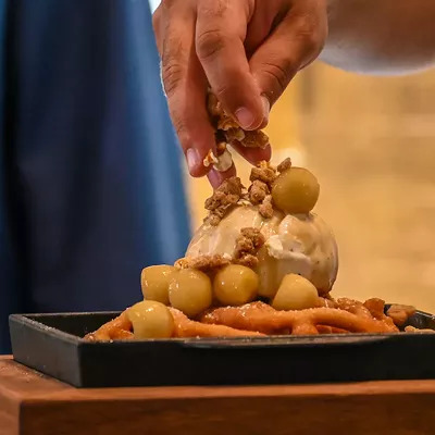 The Johnny Bench's Apple Caramel Funnel Cake being topped with Cracker Jack streusel