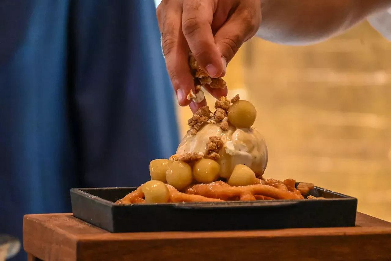 The Johnny Bench's Apple Caramel Funnel Cake being topped with Cracker Jack streusel