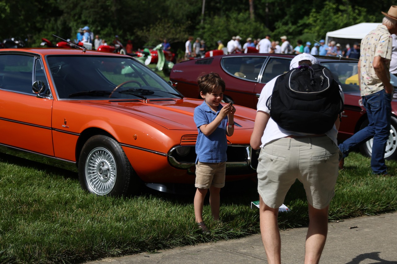 A young child poses for a photo at the 46th annual Cincinnati Concours d’Elegance car show on Sunday, June 9, 2024.