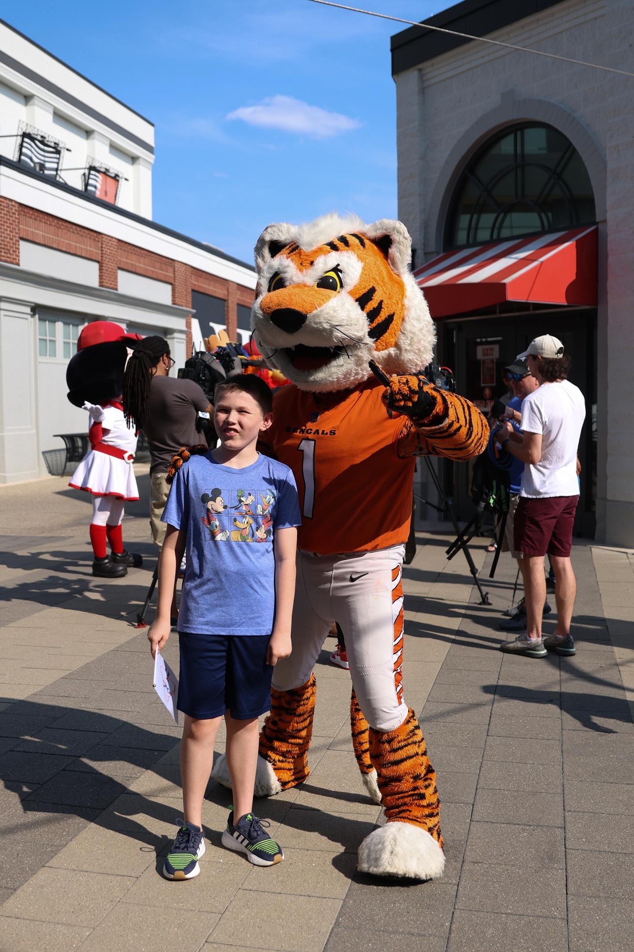 A young fan takes a photo with Who Dey at the Olympic Opening Ceremony celebration at Newport on the Levee on Friday, July 26, 2024.