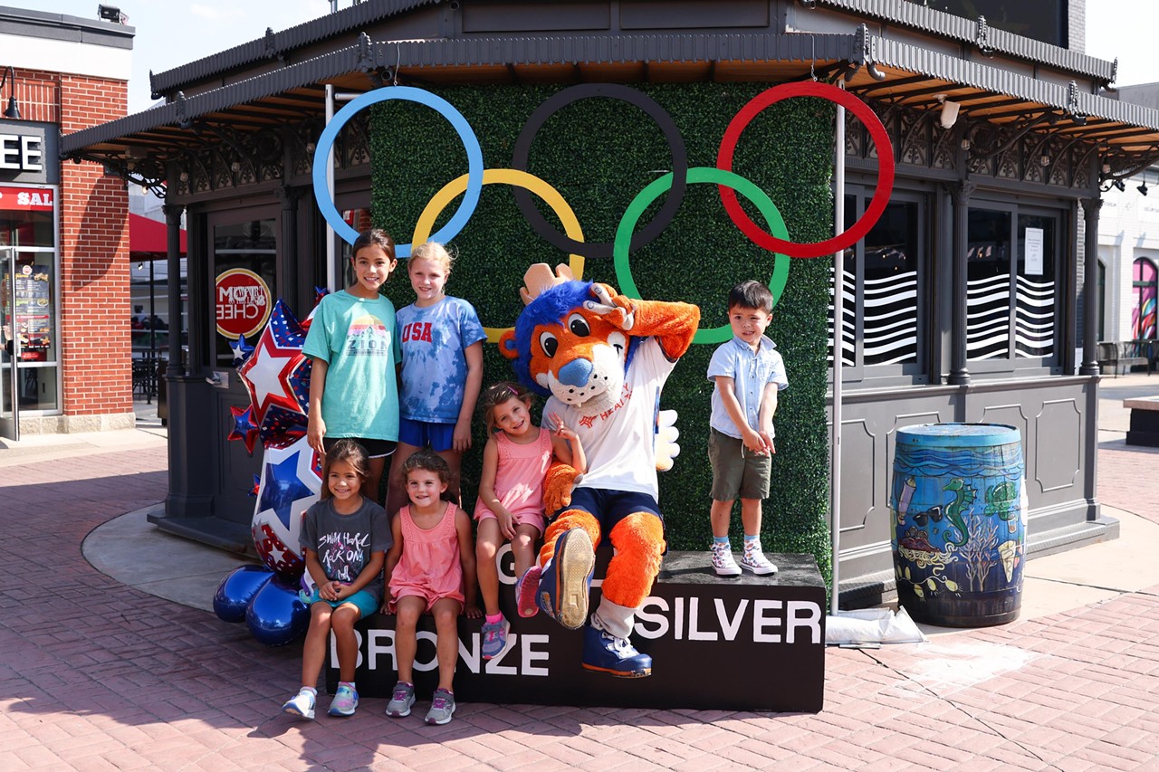 Gary the Lion takes a photo with children at the Olympic Opening Ceremony celebration at Newport on the Levee on Friday, July 26, 2024.