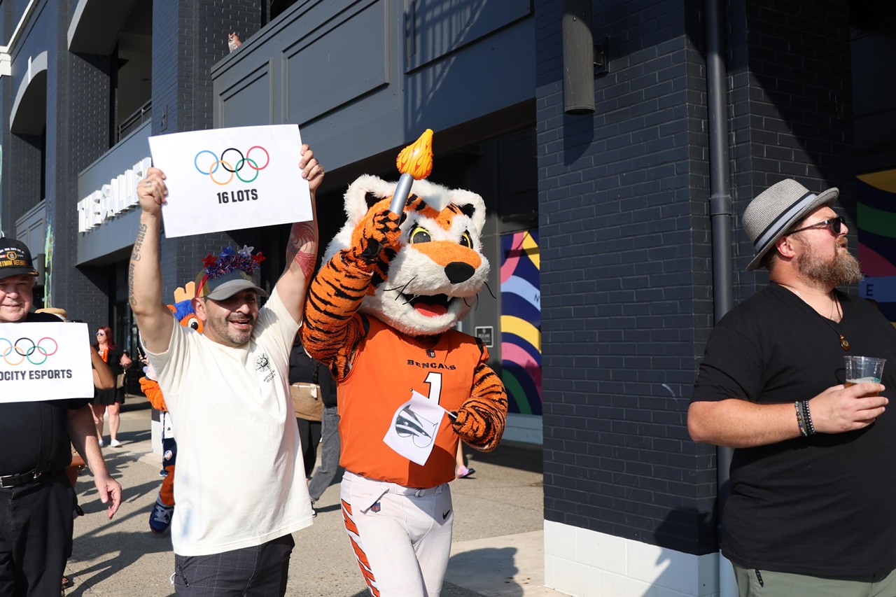 Who Dey runs the torch at the Olympic Opening Ceremony celebration at Newport on the Levee on Friday, July 26, 2024.