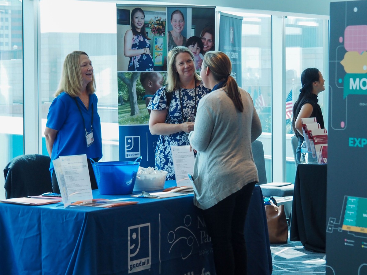 Representatives for the Goodwill Nurse-Family Partnership speak with a summit attendee on July 23, 2024, during the Labor of Love Summit at the JW Marriott Indianapolis.