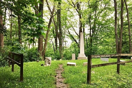 Darby-Lee CemeteryCan be accessed from the Bender Mountain Trail, 6320-6468 Bender Road, Delhi TownshipWest Siders, you may have heard of Fiddlers Green Road, but have you heard the legend of Fiddler’s Green? (Which actually has nothing to do with that particular road.) It goes back to the Darby-Lee family of Delhi Township, members of which are buried in a small graveyard at the top of Bender Mountain – the only known, remaining family cemetery in Delhi. Patriarch of the family Henry Darby was rumored to have been part of the Underground Railroad. The legend of Fiddler’s Green goes that he would sit up on the ridge of his property overlooking the Ohio River into Kentucky. When it was safe for those fleeing enslavement to cross the river and come up the ridge to his home, Darby would light a lantern with a green flame and play his fiddle. On some nights now, you can supposedly see an otherworldly green glow from the cemetery and hear the strains from a fiddle being played nearby.