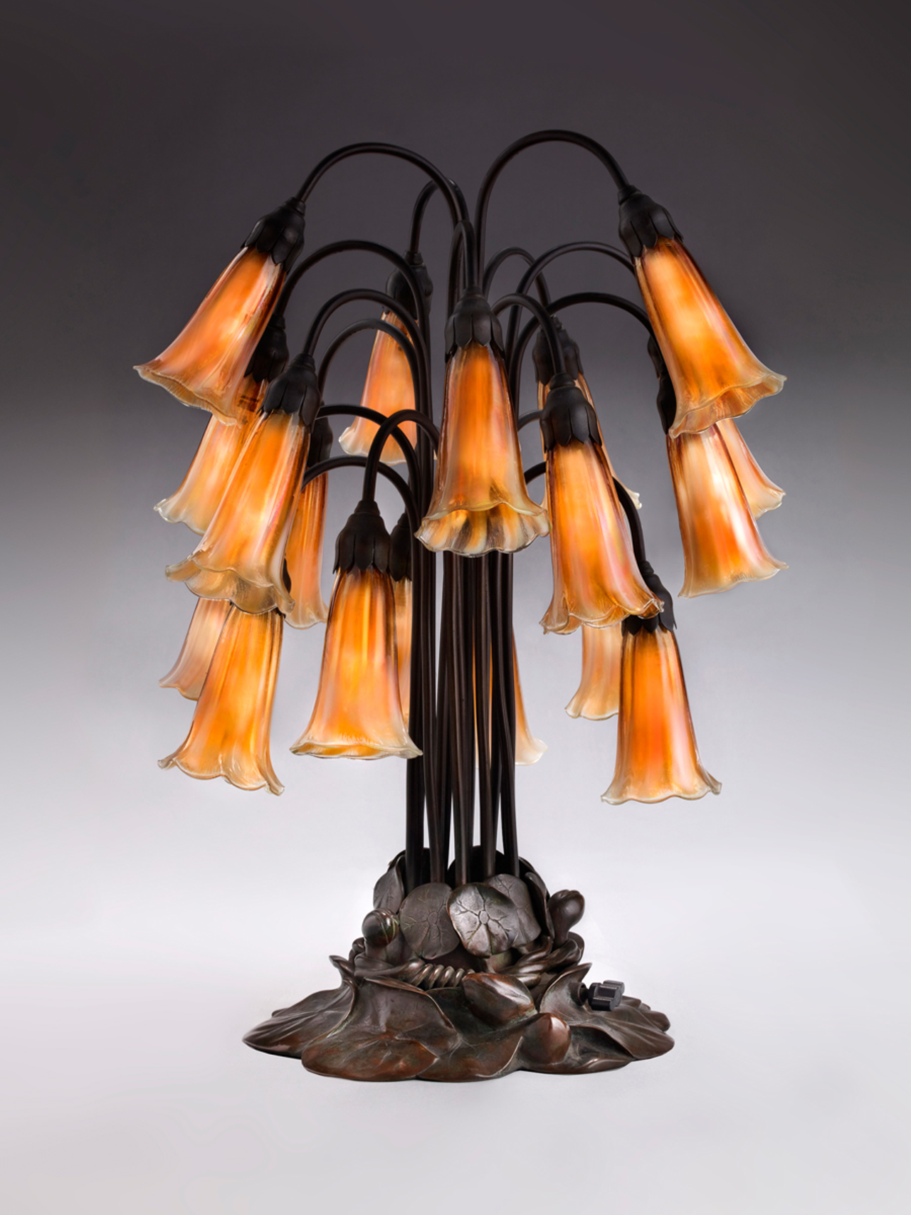 Tiffany Glass & Decorating Company, Eighteen-Light Lily Table Lamp, prior to 1902, bronze, blown glass.